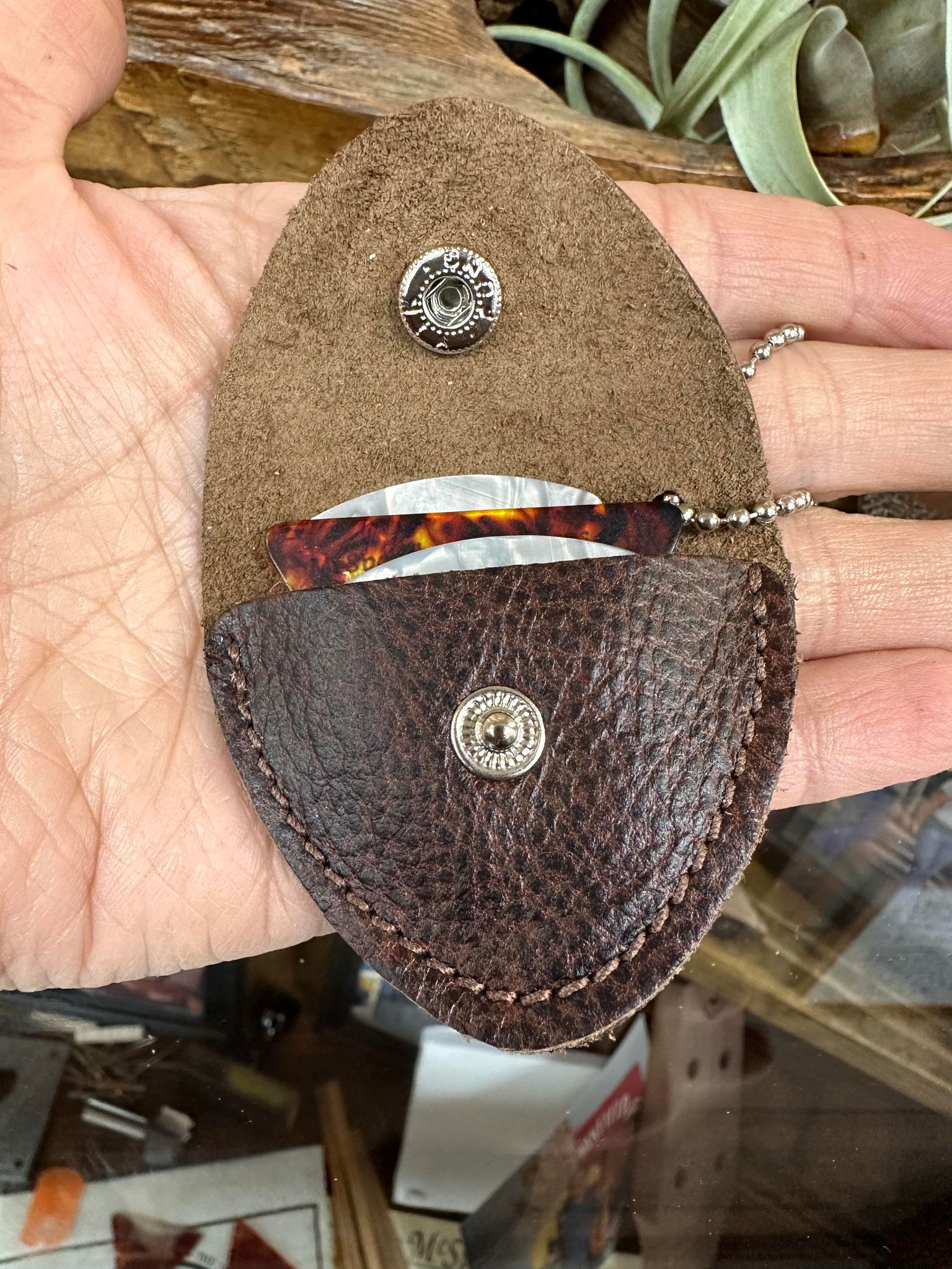 A person holding a Handcrafted Leather Pick Pack with a key ring, the perfect storage solution.