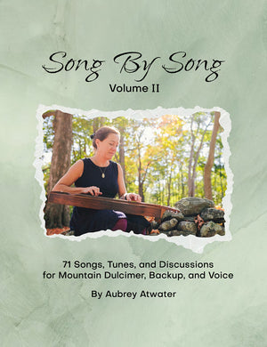 A woman playing a mountain dulcimer outdoors, featured on the cover of Song by Song Vol 2 by Aubrey Atwater, a 130-page songbook.