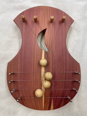 A handcrafted TK O'Brien Door Harps with two wooden balls on it.