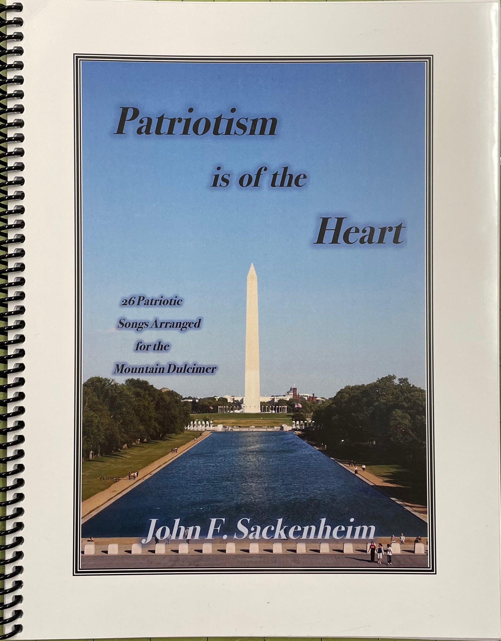 A music book titled "Patriotism is of the Heart" containing 26 patriotic tunes arranged for the mountain dulcimer in DAd tuning, authored by John Sackenheim.