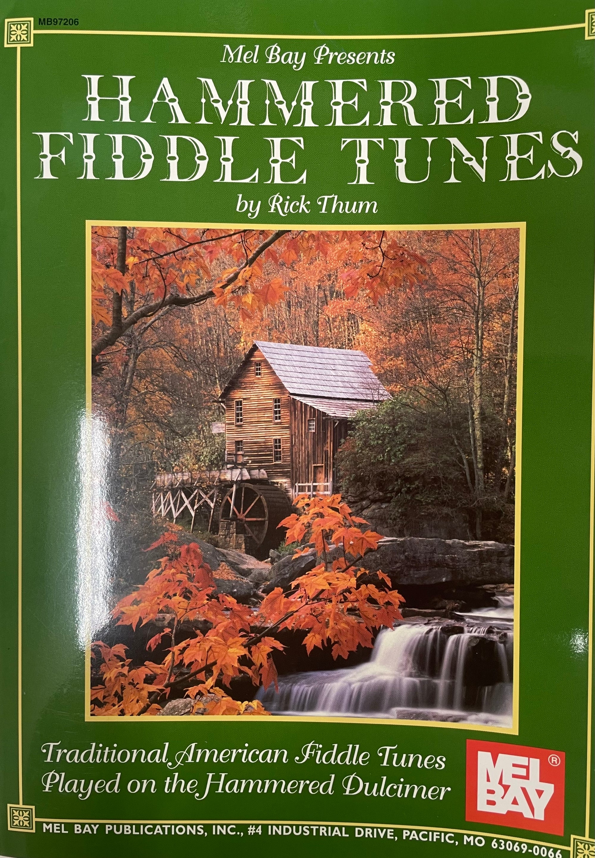 A book cover titled "Hammered Fiddle Tunes by Rick Thum," featuring an autumnal scene with a wooden mill house by a waterfall. Subtitle: "Traditional American Fiddle Tunes Played on the Hammered Dulcimer." The cover beautifully captures the essence of traditional American fiddle tunes and the hammered dulcimer.