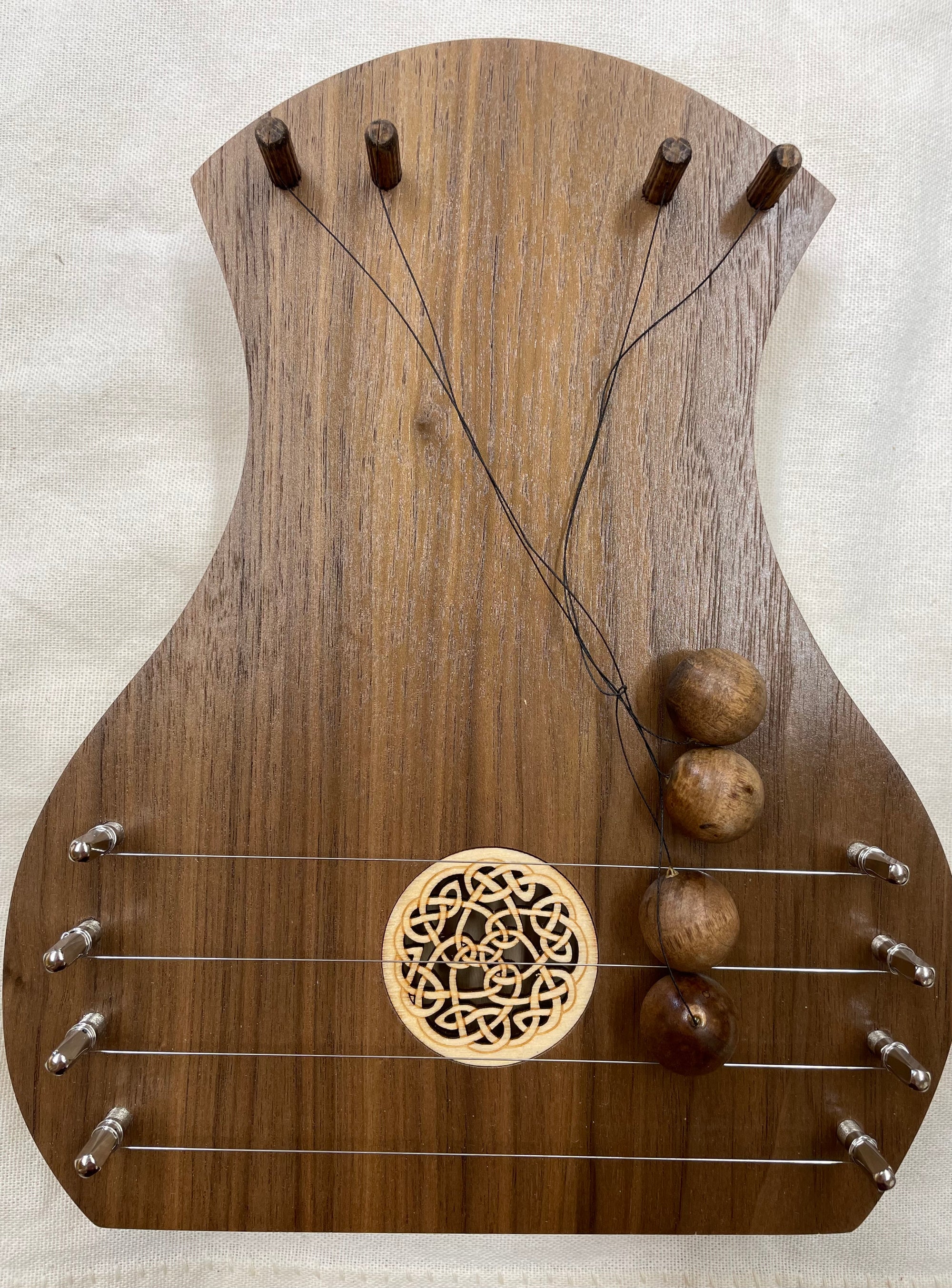 A handcrafted TK O'Brien Door Harp with strings and beads.