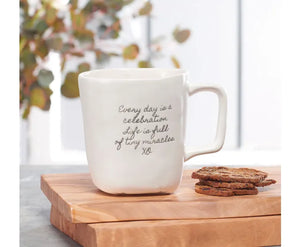 A handmade ceramic mug from the Studio M Coffee Mugs collection with a cookie on it.