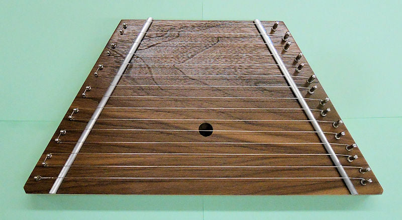 A Lap Harp Walnut, a wooden acoustic folk instrument, with metal wires on it.
