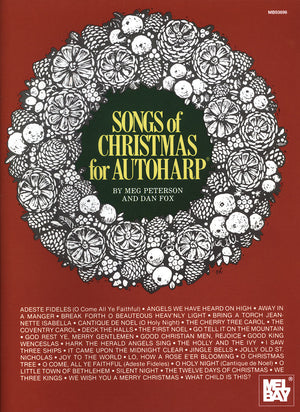 A red book cover titled "Songs of Christmas for Autoharp by Meg Peterson and Dan Fox," featuring a white decorative wreath design surrounding the title and a list of Christmas songs at the bottom.