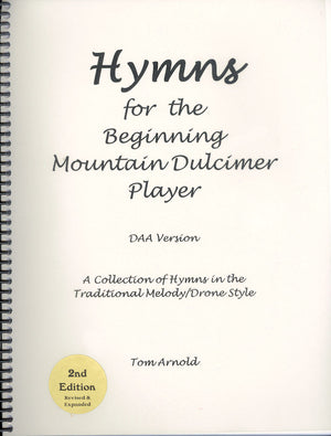 Cover of a spiral-bound book titled "Hymns for the Beginning Mountain Dulcimer Player (DAA) by Tom Arnold." It is the 2nd edition, revised and expanded to include traditional melody/drone style arrangements for beginners.