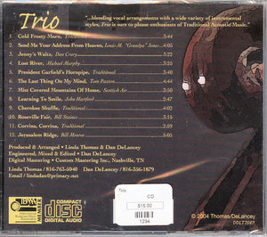 Back cover of "Trio" music CD by Linda Thomas, Dan and Ronnie Delancey featuring a tracklist, barcodes, and price tag, overlaid on a Celtic knot design background.