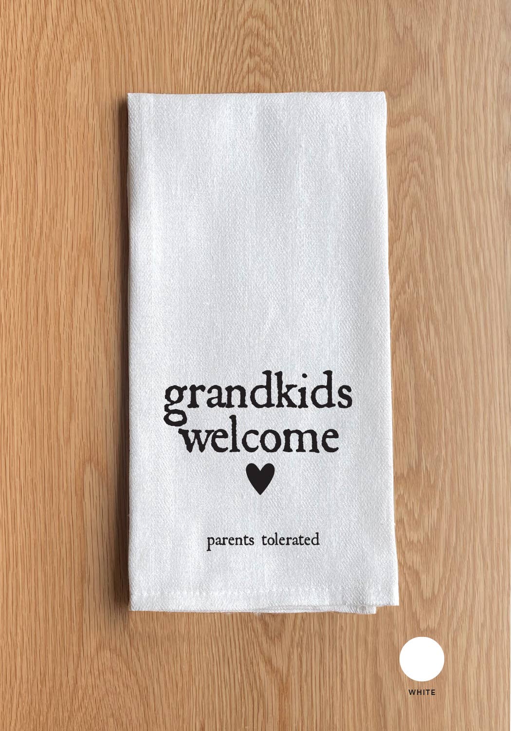 The Grandkids Welcome White Kitchen Towel features the playful text "Grandkids welcome" and "Parents tolerated," complete with a charming heart graphic, displayed beautifully on a wooden surface.