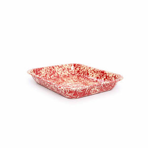 The Splatter Enamelware Large Open Roaster, in a rectangular shape with red and white speckles and a slightly raised edge, is shown from a low angle; it's both durable and easy to clean.