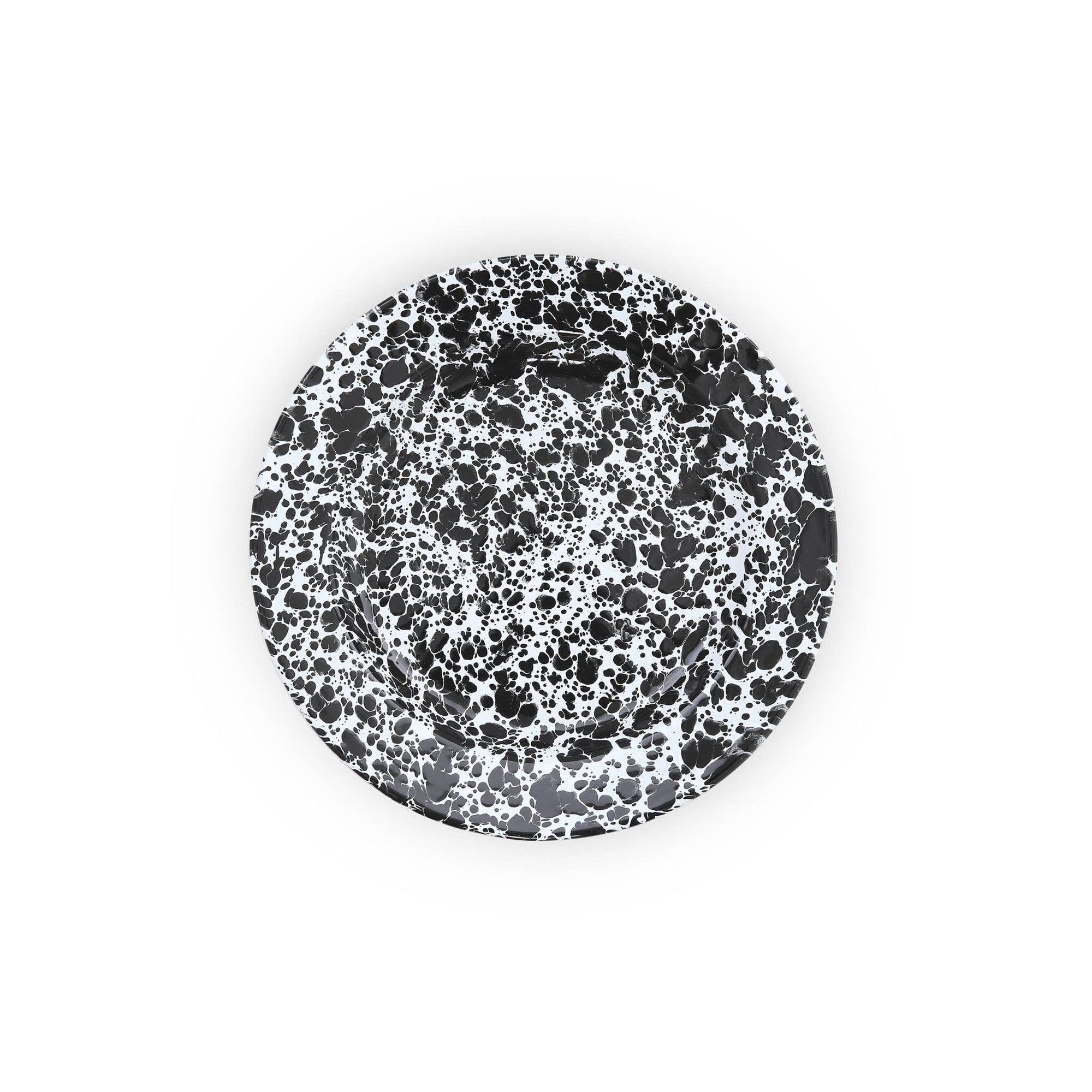 The Splatter Enamelware Dinner Plate, with its round shape and black-and-white splatter pattern on a crisp white background, adds a touch of whimsy to any table setting.