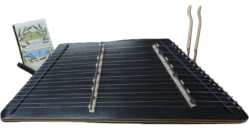 The One String 9/8 Fledgling Songbird Hammered Dulcimer comes with twelve strings, two wooden hammers, and the book "My First Hammered Dulcimer," making it ideal for young musicians eager to explore a kids dulcimer.