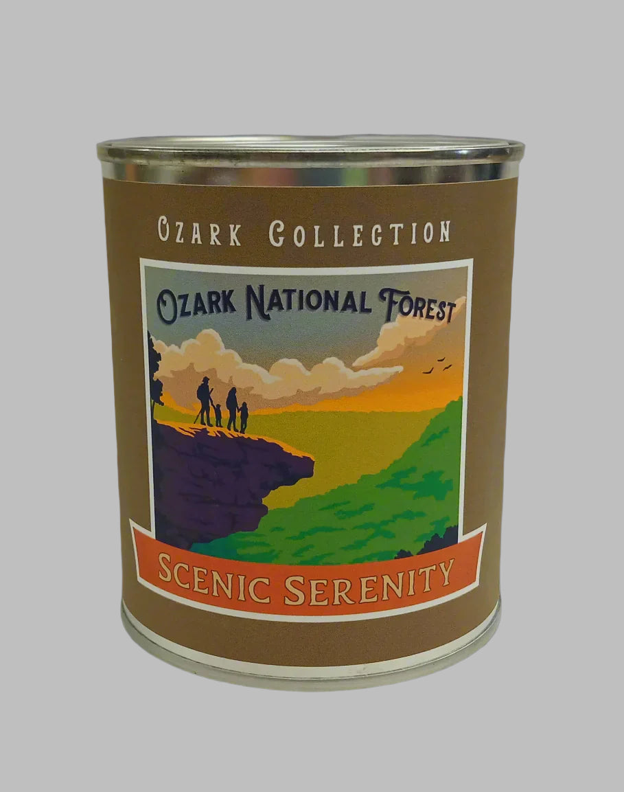 The "Scenic Serenity" candle from The Scented Palette features an illustration of people on a cliff enjoying a breathtaking view as part of the Ozark Collection.