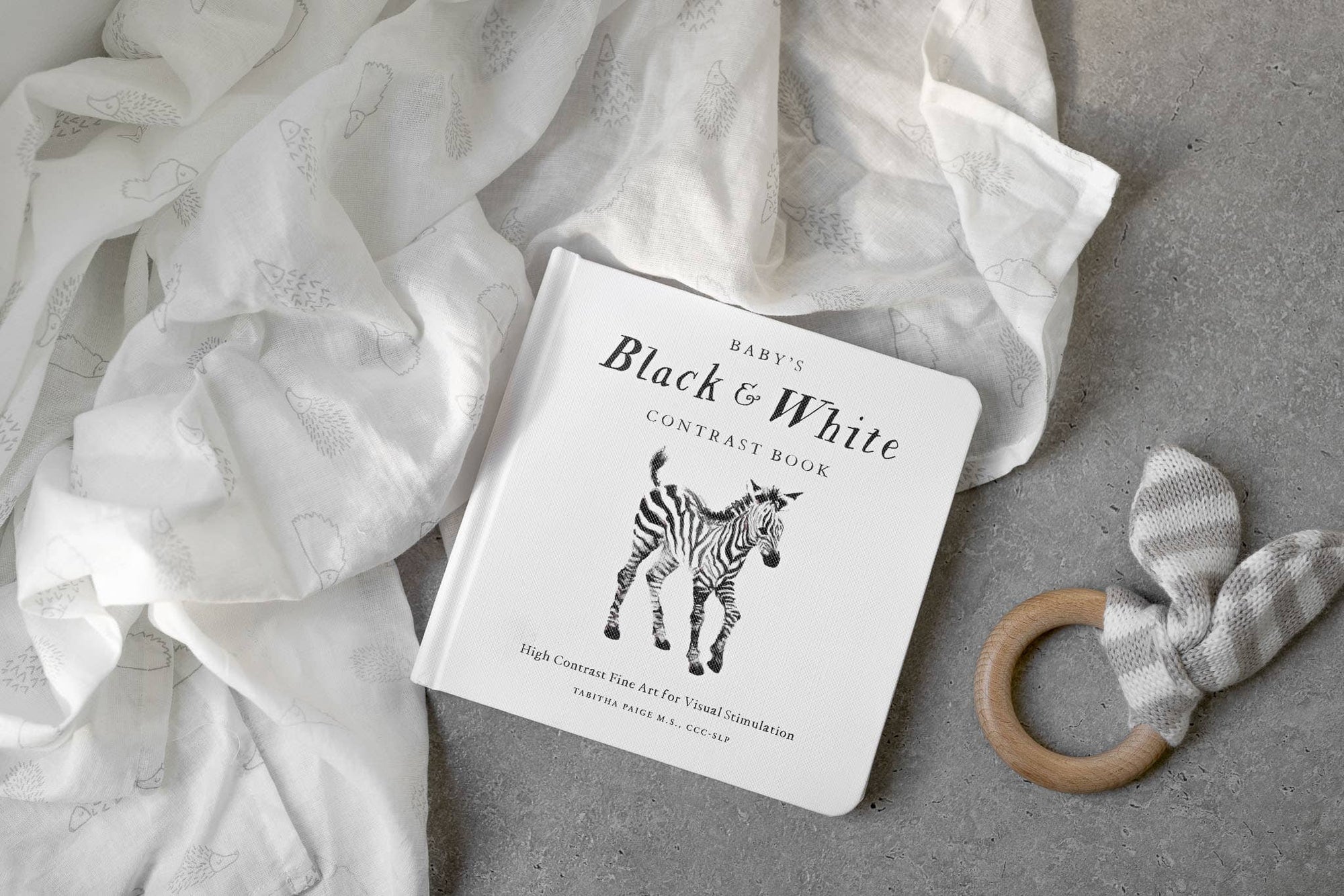 A visually stimulating Baby's Black and White Contrast Book featuring high-contrast images of a zebra and a teddy bear.