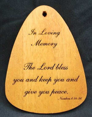 A wooden plaque that serves as a memorial tribute, engraved with the words "In Loving Memory® Bronze 24-inch Windchime" and a heartfelt message of peace.