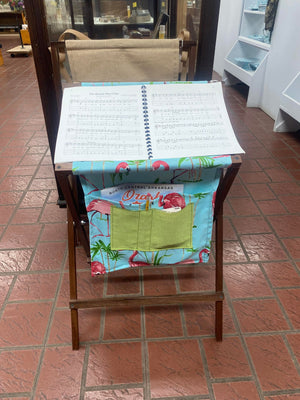 A Sling Music Stand in a store featuring a vibrant flamingo design.