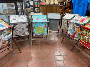 A row of folding chairs in a store, with each chair featuring a convenient Sling Music Stand attachment for added comfort.