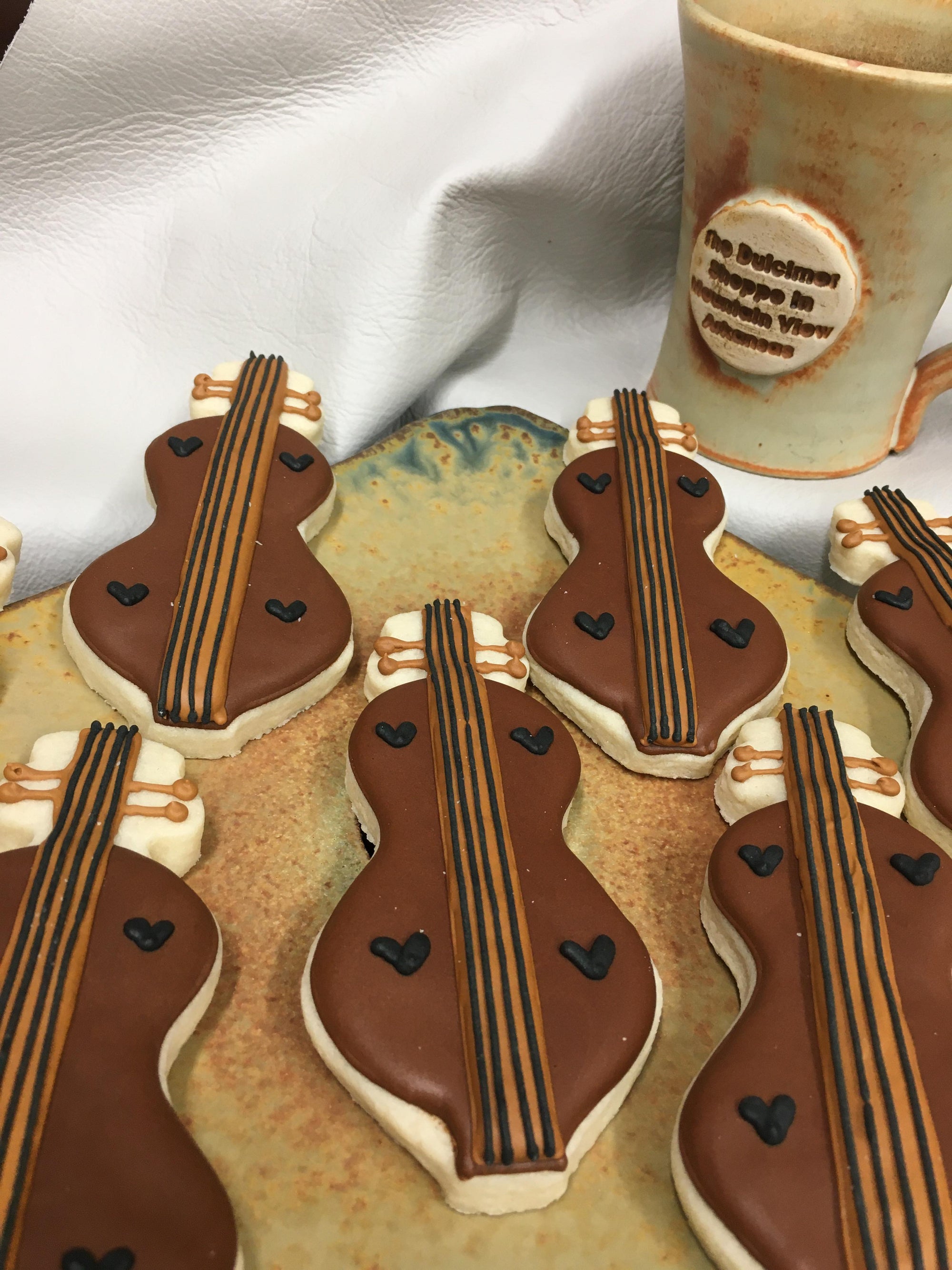 A plate of cookies with a dulcimer cookie cutter on it, showcasing baking skills.