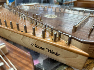 A wooden harp, also known as a Master Works Bowed Psaltery or Master Works Psaltery, is on display in a shop, showcasing the harmonious beauty of music.