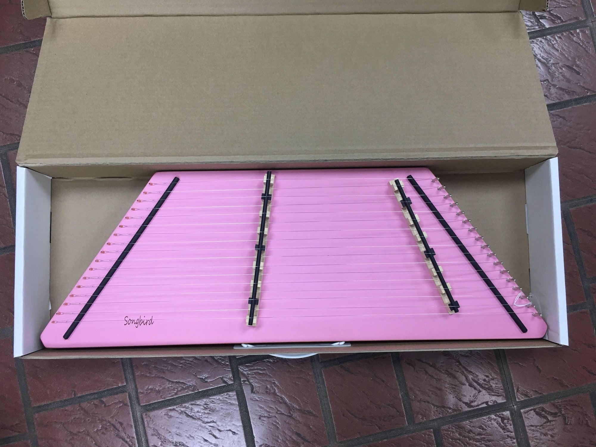 A small and light pink One String 9/8 Fledgling Songbird Hammered Dulcimer with a clear sweet sound.