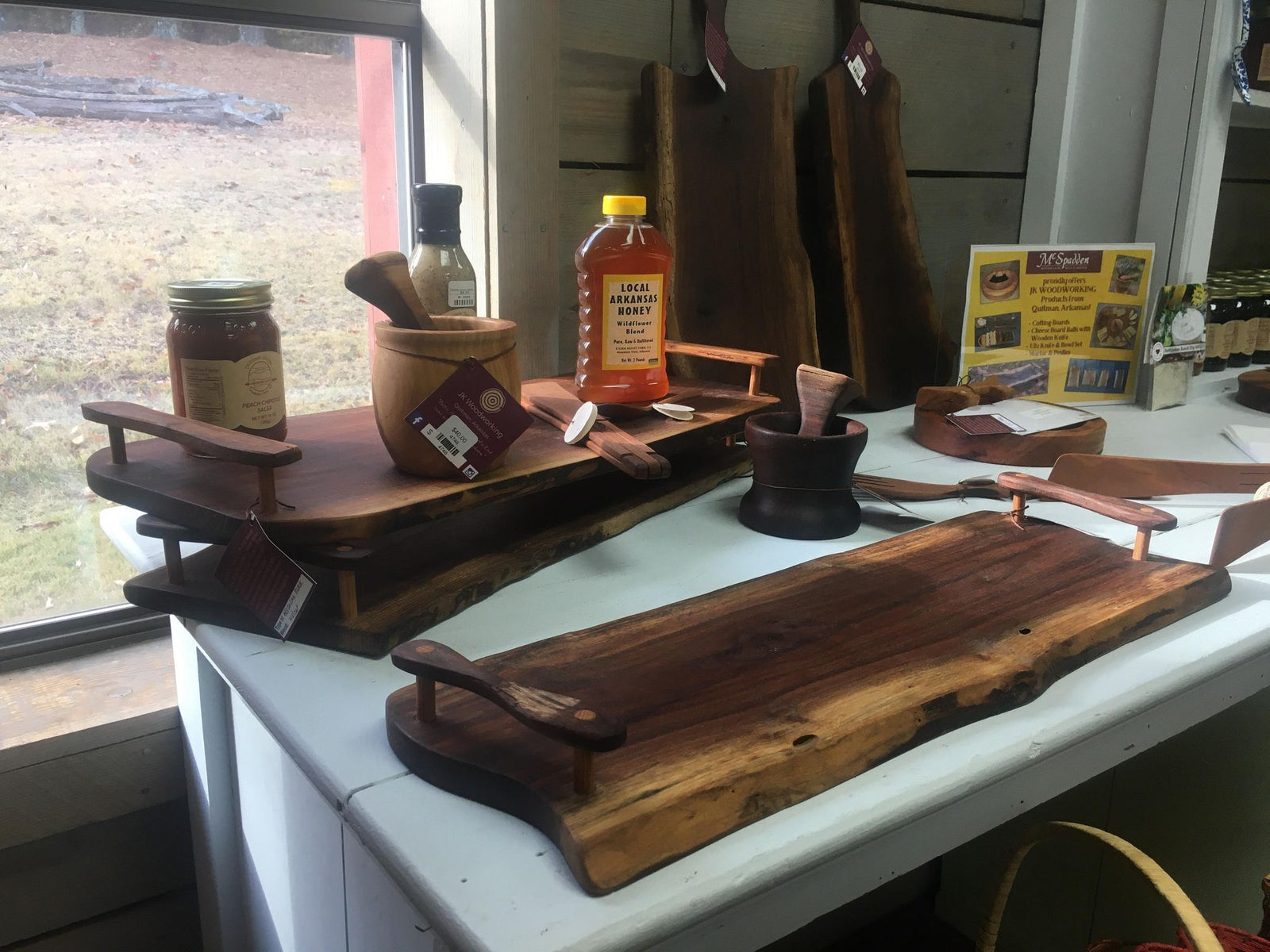 A Handcrafted Charcuterie Board with Handles with a bottle of honey on it.