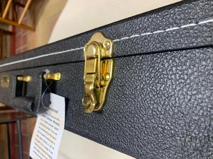 A black Premier Dulcimer Hardshell Case with a gold latch on it.