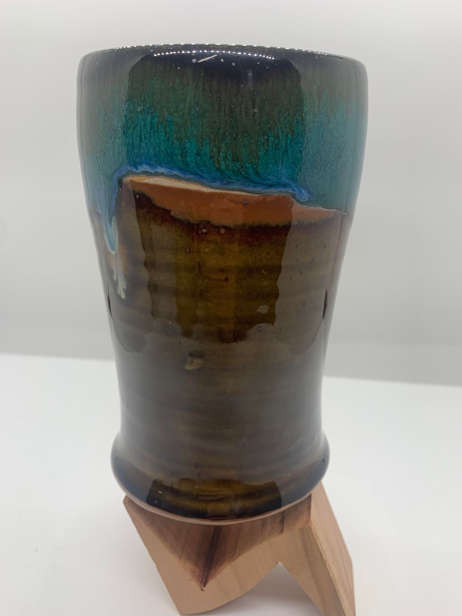 A Perry Munn Pottery Tumbler set on a wooden stand.