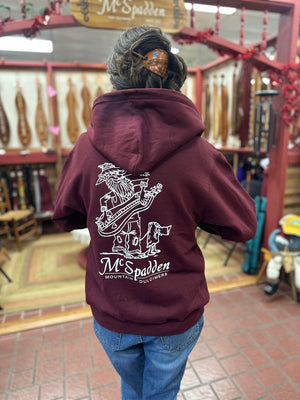 A woman wearing Dulcimer Shoppe Hoodies in a store, looking comfortable in the high-quality materials.