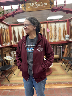 A woman in Dulcimer Shoppe Hoodies standing in a store.