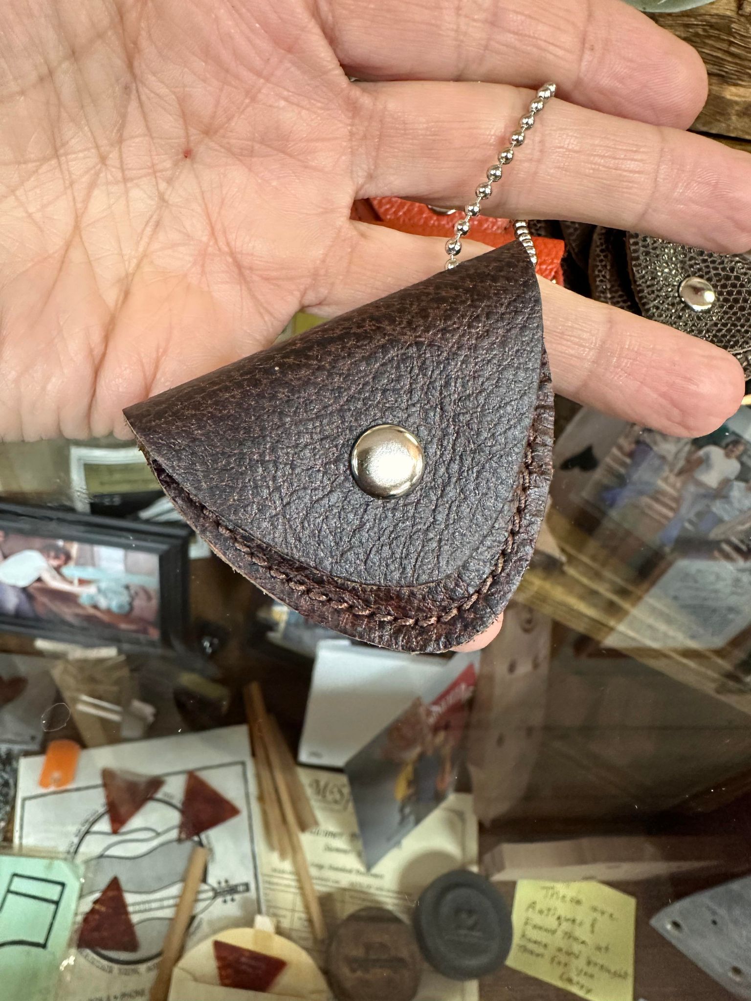 A person displaying a handcrafted leather Pick Pack, the perfect storage solution for loose change.
