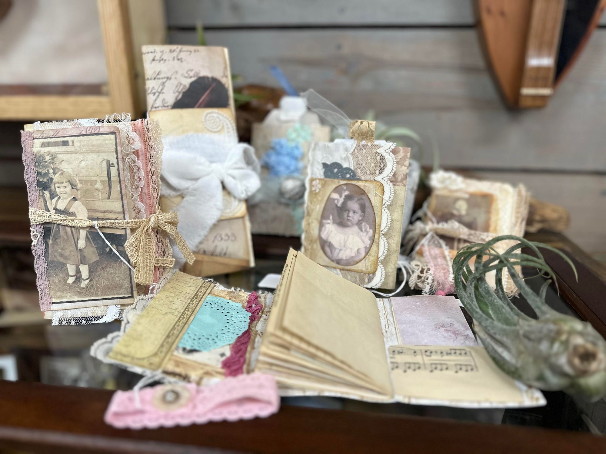 A collection of Mrs. Pat's Junk Journals and photos on a table by a local artist.