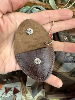 A Handcrafted Leather Pick Pack, a person holding a brown leather coin purse.