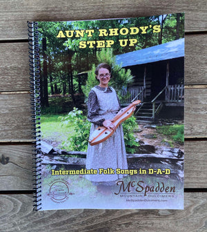 Cover of the intermediate book titled "Aunt Rhody's Step Up - by Red Dog Jam" featuring a woman in a historic dress holding a dulcimer on a wooden porch. Published by McSpadden Mountain Dulcimers.