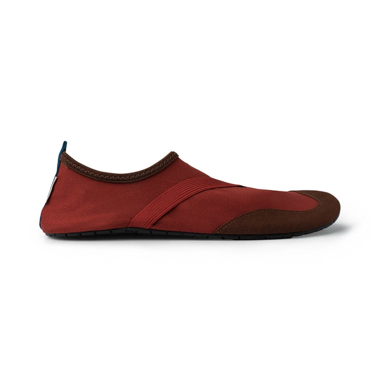 A red minimalist slip-on shoe with a rubber sole, designed as Men's Classic Fitkicks, displayed against a white background.