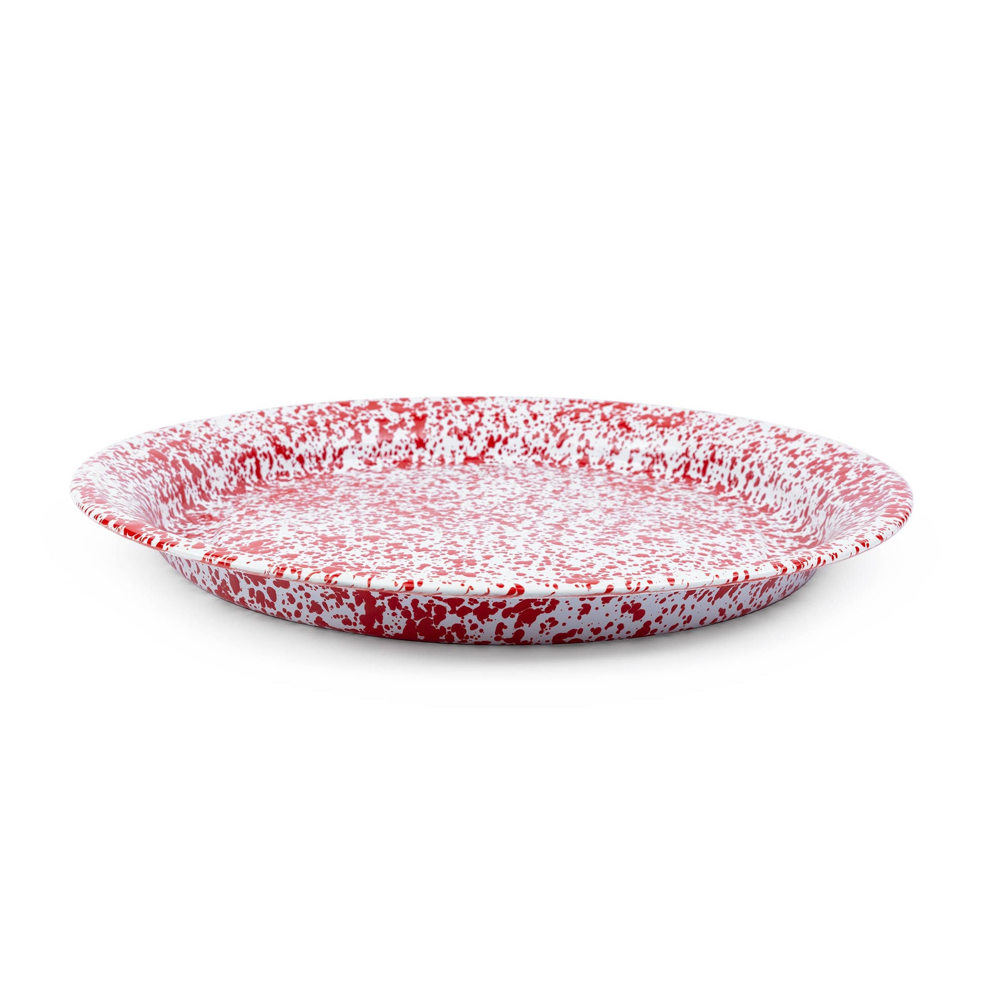 The Splatter Enamelware Large Round Tray, featuring a red and white speckled design and shallow depth, viewed from a slight angle, resembles an elegant serving tray perfect for any occasion.