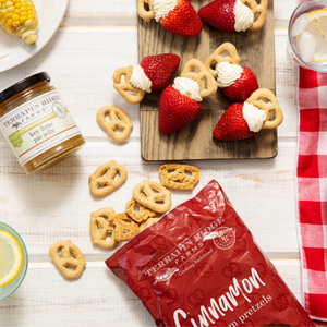 Overhead view of a dessert dips arrangement with strawberries, snacking pretzels, and cream cheese alongside a jar of honey lime sauce and a bag of Cinnamon Graham Pretzels.