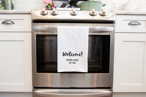 An introvert-friendly Welcome Please Leave By 9 Tea Towel with the word welcome on it.