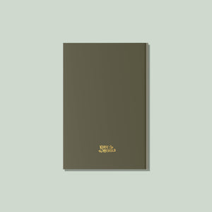An olive green closed hardcover "My Travel Journal" features “Korie Herold” and a gold floral graphic centered on the front, set against a light background.