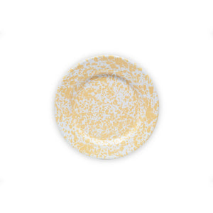 The Splatter Enamelware Flat Salad Plate, featuring a vibrant yellow and white splatter pattern on its round surface, is viewed from above. Set against a plain white background, the durable plate proudly displays its versatile design.