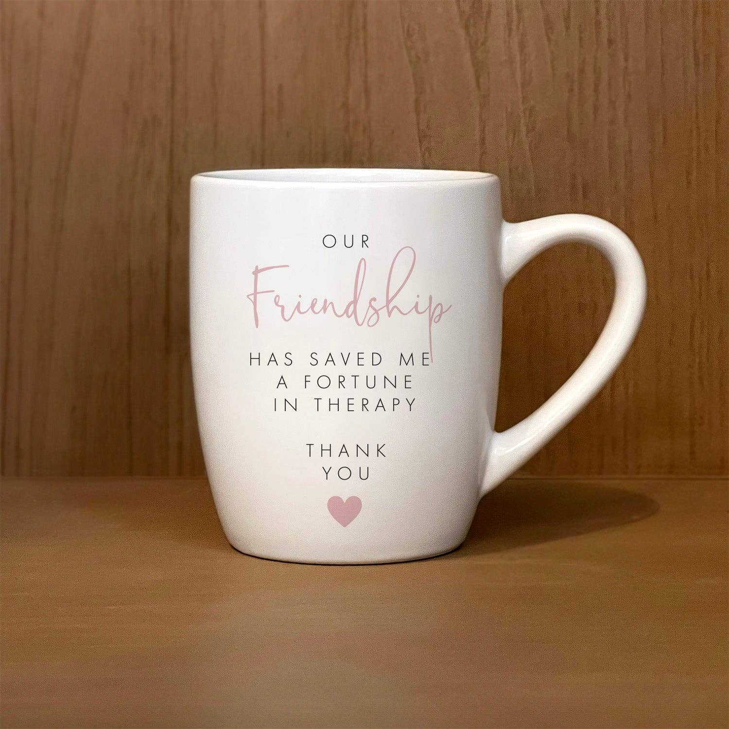 White mug with the printed text: "Our friendship has saved me a fortune in therapy. Thank you," accompanied by a small heart icon. Perfect addition to your collection of mugs, reminding both you and your friend of the value of true connection. Product name: "Our friendship has saved me a fortune in therapy. Thank you.