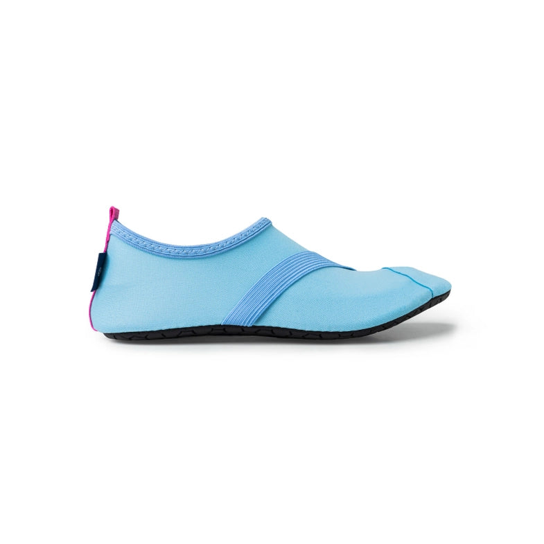 A light blue minimalist shoe with a slip-on design and a black sole, isolated on a white background. Designed as women's classic FITKICKS, this active footwear is water-friendly.