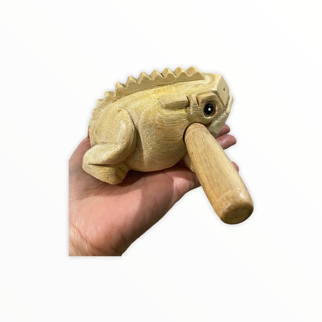 A person holds a Natural wooden frog, a handmade percussion instrument from Thailand known for its quality craftsmanship, using a stick to produce sound by striking or scraping its ridged back.