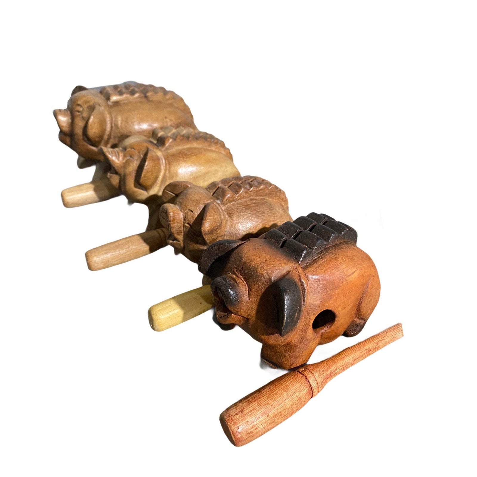 Four Wooden Musical Pig Percussion Instruments of varying sizes with wooden scrapers, lined up in a row on a white background, create a charming ensemble resembling playful musical toys.