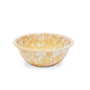 The Splatter Enamelware Small Serving Bowl, featuring a round shape and white surface adorned with light brown speckled patterns, is part of a vibrant enamelware collection and is showcased against a plain white background.