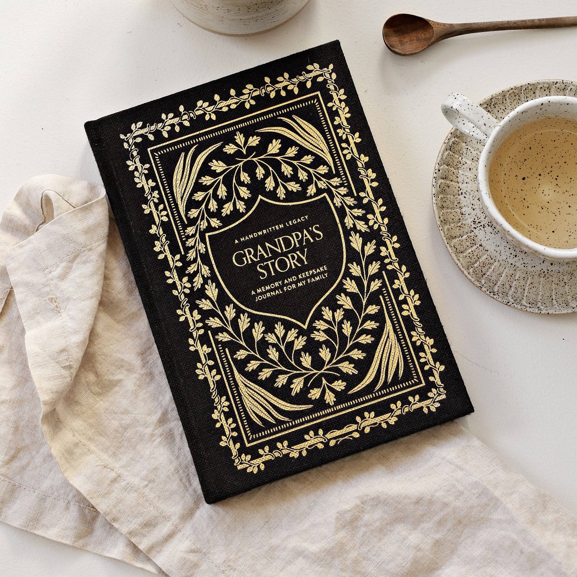 Grandpa's Story: A Memory and Keepsake Journal for My Family accompanied by a cup of coffee, perfect for recording cherished moments with grandpa through engaging writing prompts.
