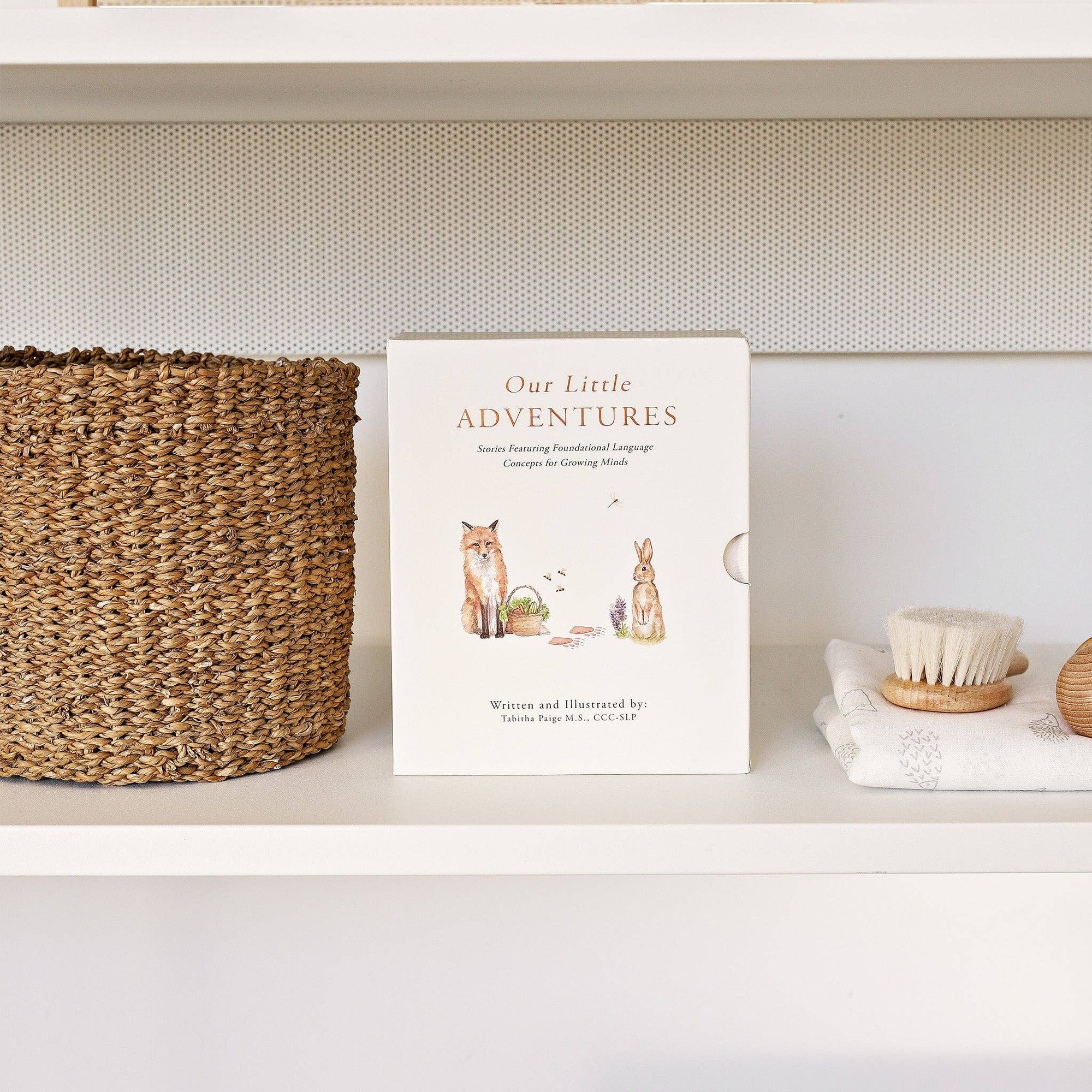 Our Little Adventures Box Set on language development and nature adventures, displayed on a shelf next to a basket.