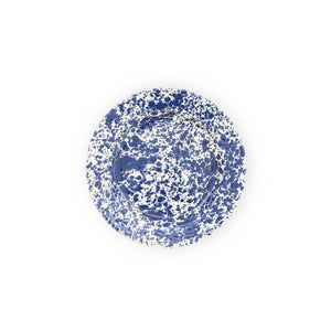 The Splatter Enamelware Flat Salad Plate is a versatile round plate featuring a blue and white speckled pattern on a white background, showcasing the durability of premium enamelware.