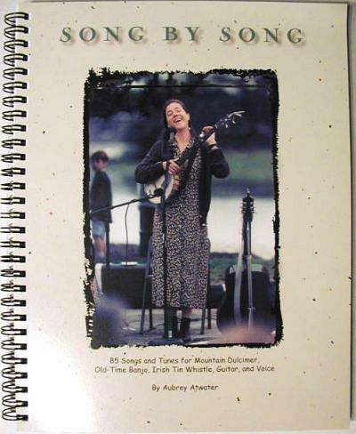 Cover of the 130-page songbook "Song by Song Vol 1 by Aubrey Atwater" featuring Aubrey Atwater playing a guitar, with text about the book’s content including different musical instruments.