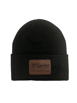 The Beanie Knit Cap with McSpadden Logo Patch is a black knit beanie featuring a folded brim and a brown rectangular patch with the "McSpadden" logo on the front.