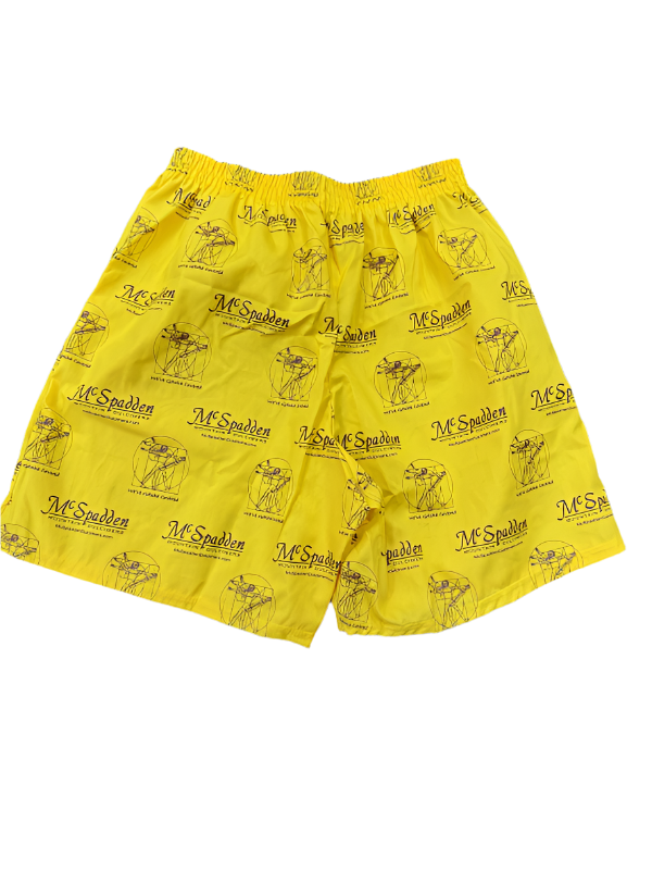 Boxer Shorts-McSpadden Vitruvian Man: Yellow flyless boxers with an elastic waistband, a repeating black McSpadden logo, and a dulcimer graphic, displayed on a gray textured surface.