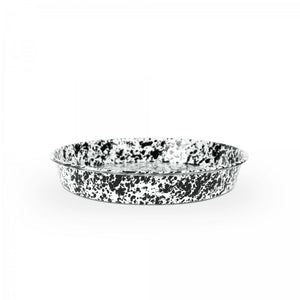 Pictured on a plain white background is the Splatter Enamelware Cocktail Tray/Deep Dish Pizza Pan—a round, shallow enamel dish featuring a black and white speckled pattern and designed for versatile oven-to-table use.